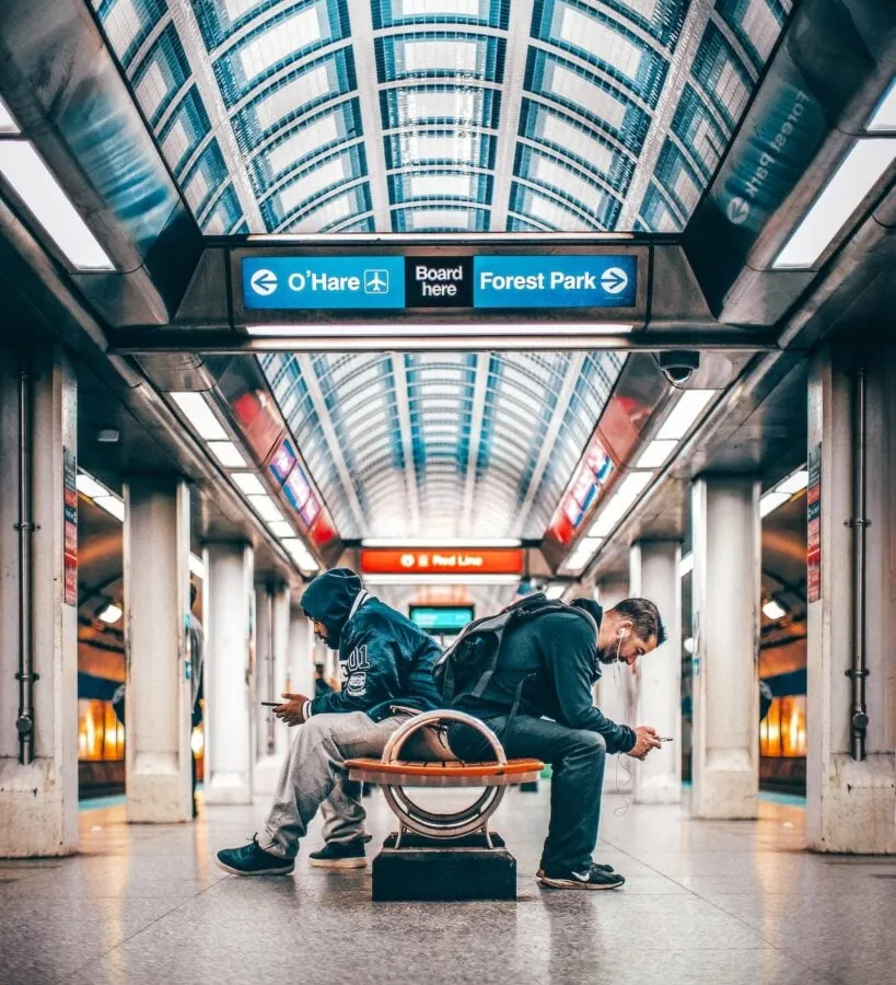 Reisende warten in einem modernen Bahnhof