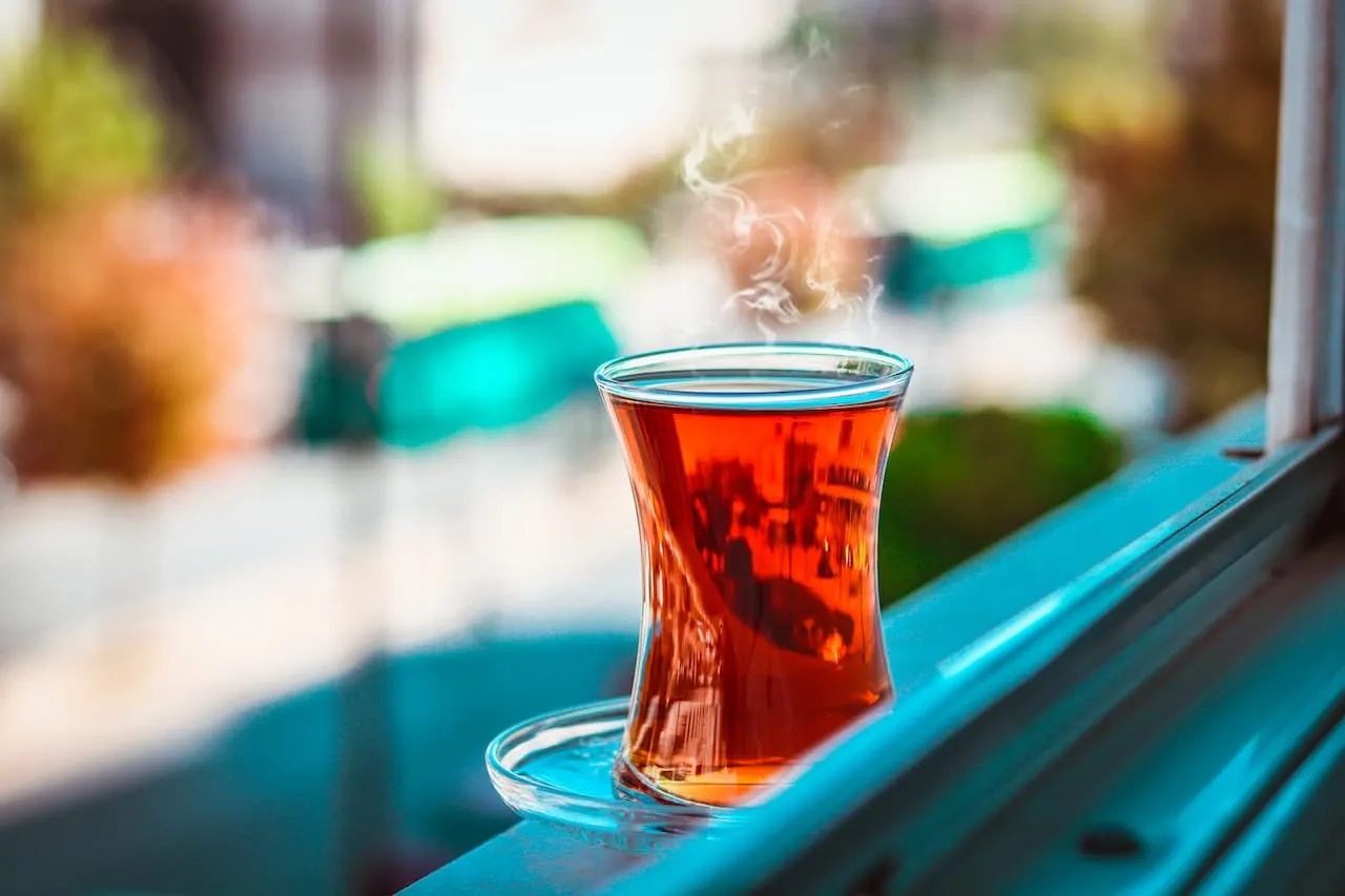 Glas Turkse thee naast een treinraam