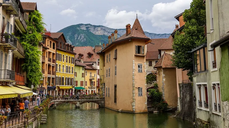 Het kanaal en de stenen brug van de oude binnenstad van Annecy met bergen op de achtergrond.