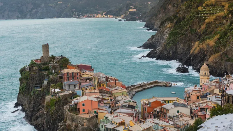De kleurrijke haven van Vernazza en de huizen langs de kliffen aan de kust van Cinque Terre.
