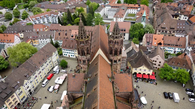Luchtfoto van de torenspitsen van het Freiburger Münster boven het Münsterplatz en de marktkramen in de oude binnenstad