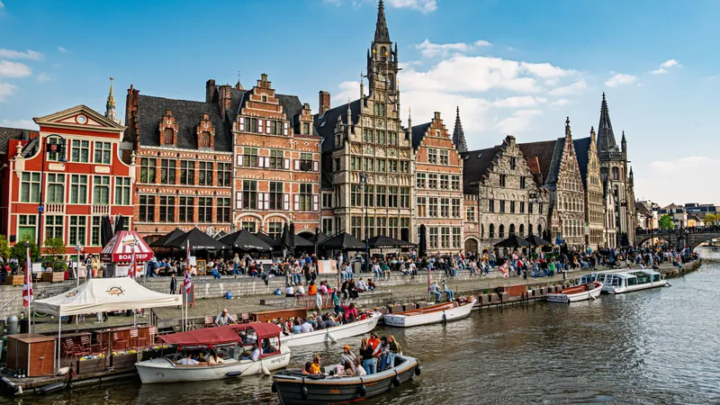 Middeleeuwse gildehuizen langs de Graslei aan de Leie in Gent, met rondvaartboten ervoor aangemeerd