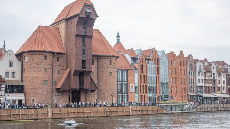De middeleeuwse Kraan (Żuraw) aan de Motława in Gdańsk, met bakstenen huizen met trapgevels langs de rivier