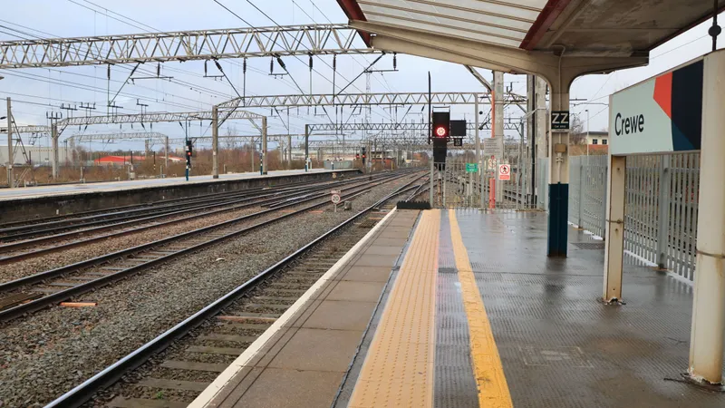 Een perron op station Crewe met het stationsbord