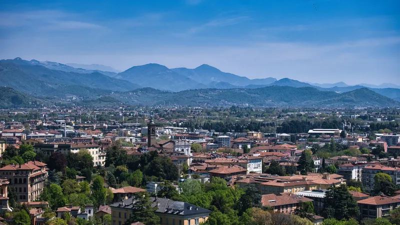 De daken en kerktorens van Bergamo, met bergen op de achtergrond.
