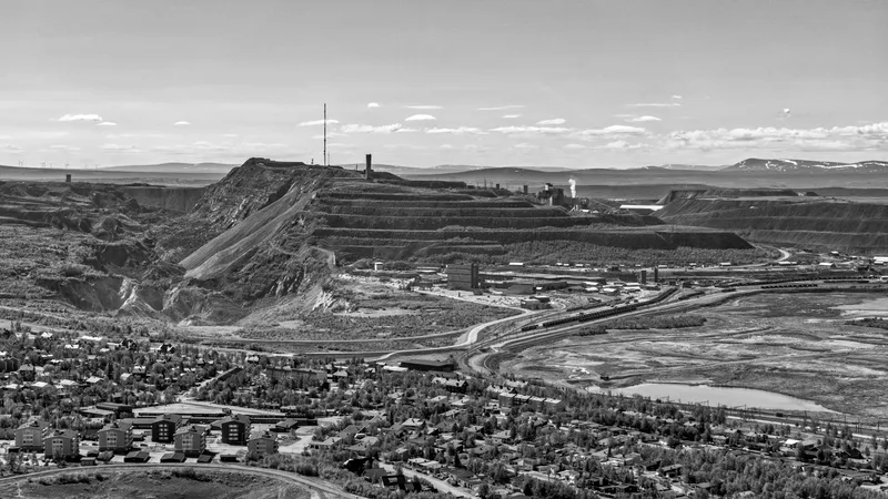 Zwart-witte luchtfoto van Kiruna onder de getrapte mijnheuvel Kiirunavaara in Zweden