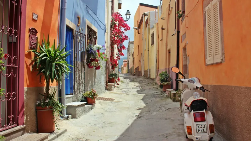 Ruelle italienne étroite avec un scooter et des maisons colorées