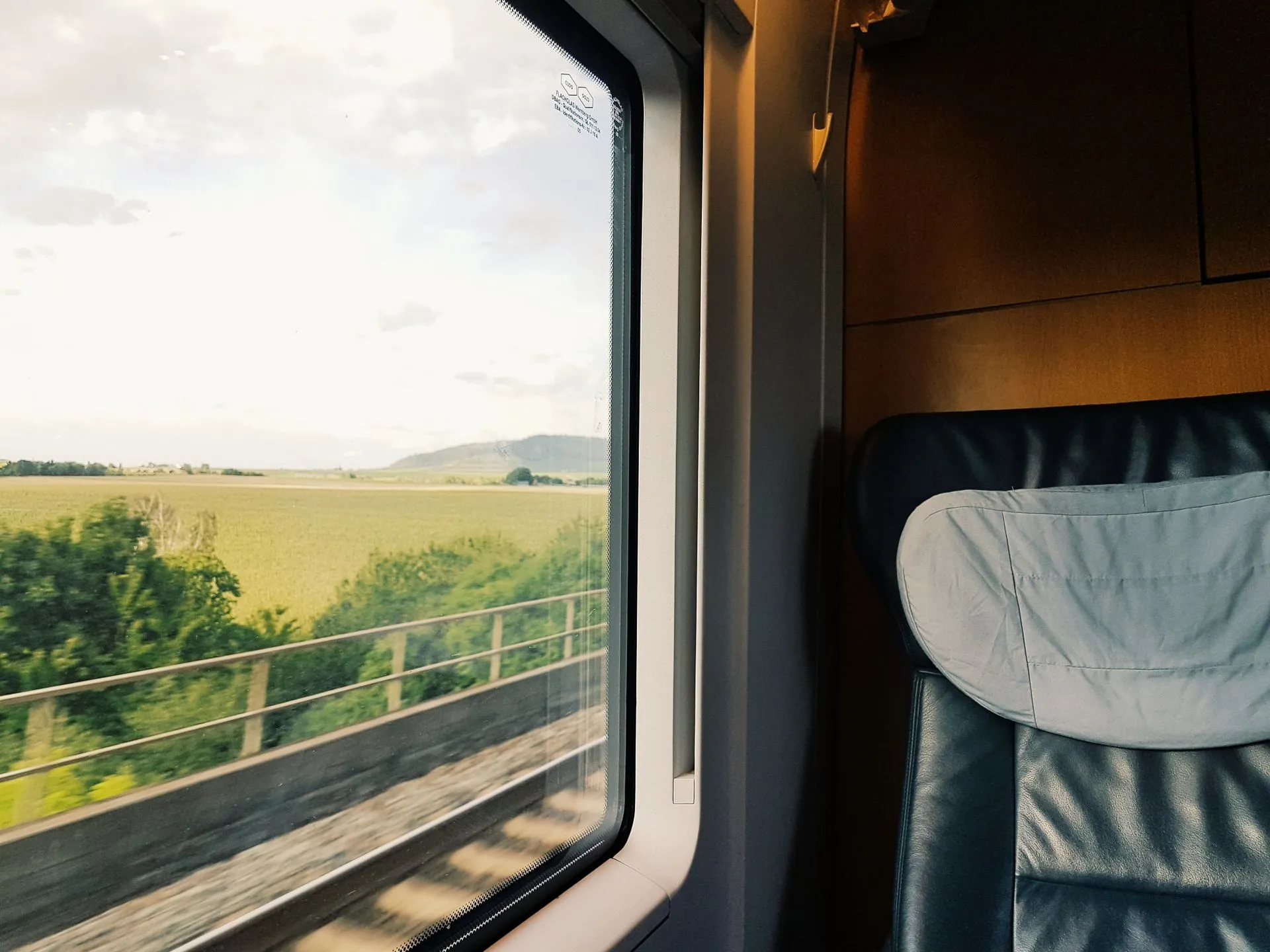 Trein arriveert bij zonsondergang op een kuststation aan een klif onder het dorp Manarola