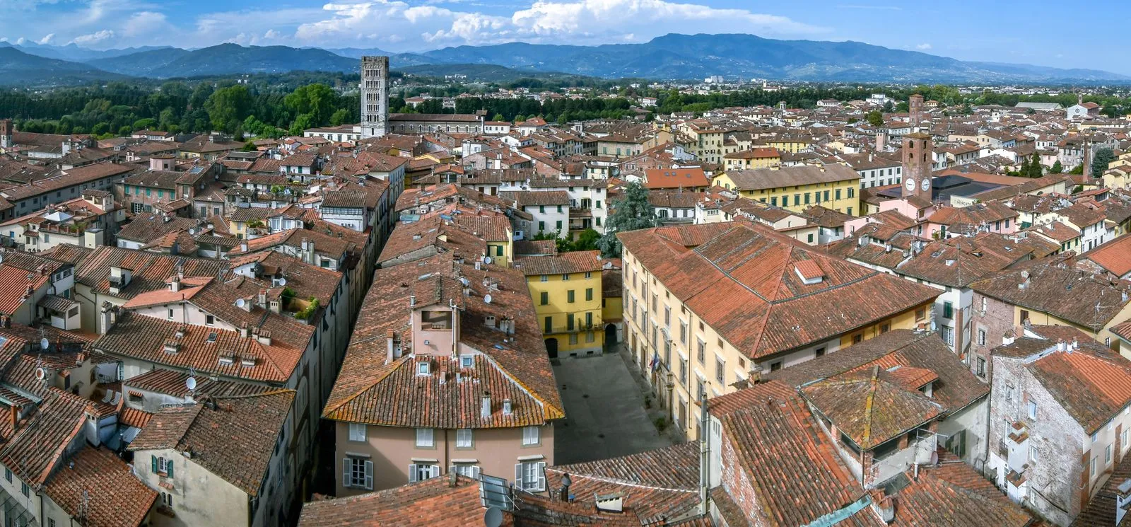 Les toits en terre cuite et les tours historiques de Lucca sous les collines toscanes.
