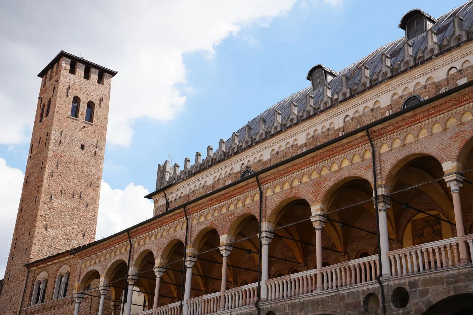 Portici storici in mattoni e una torre a Padova.