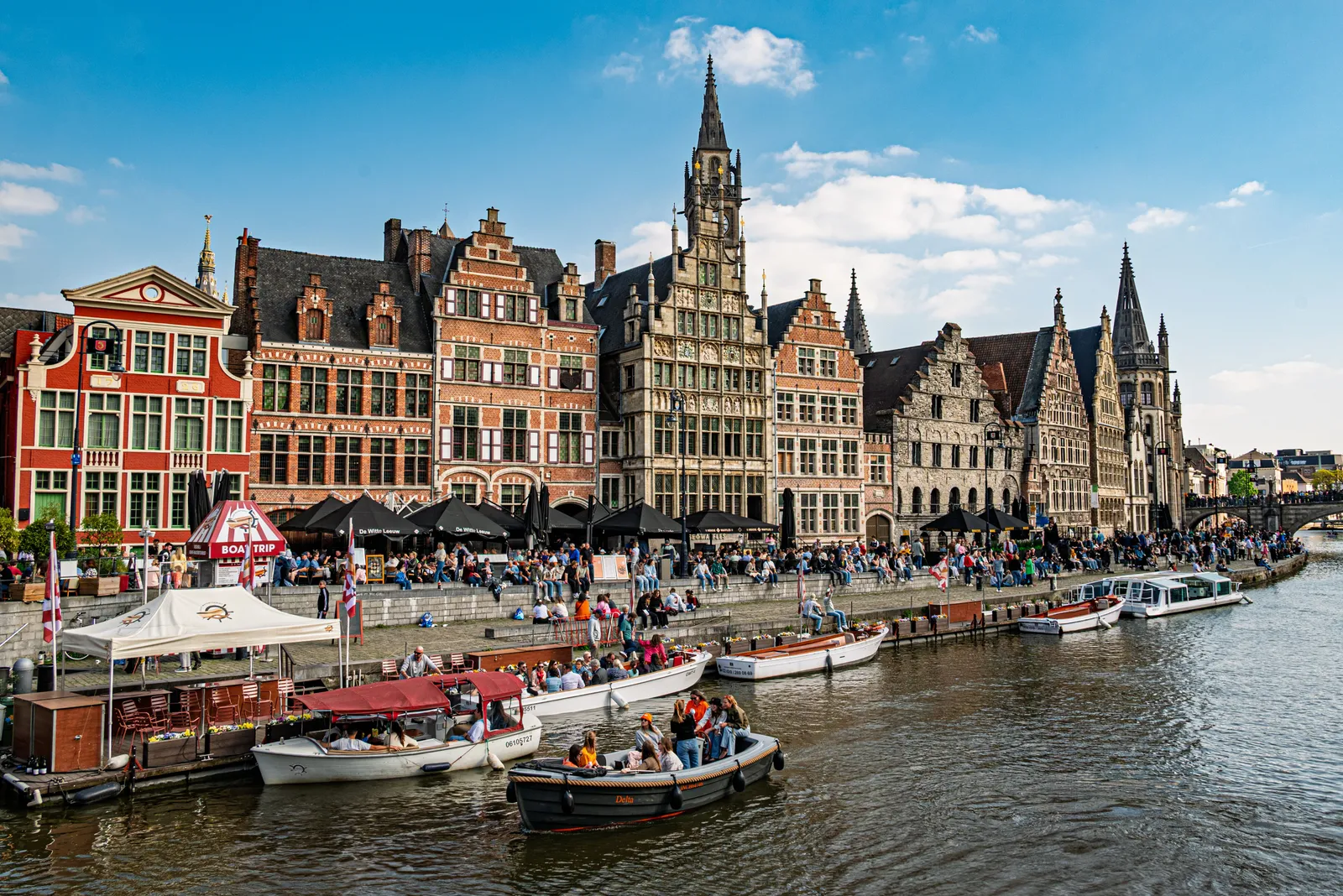 Medeltida gillehus längs kajen Graslei vid Leie i Gent, med turistbåtar förtöjda framför