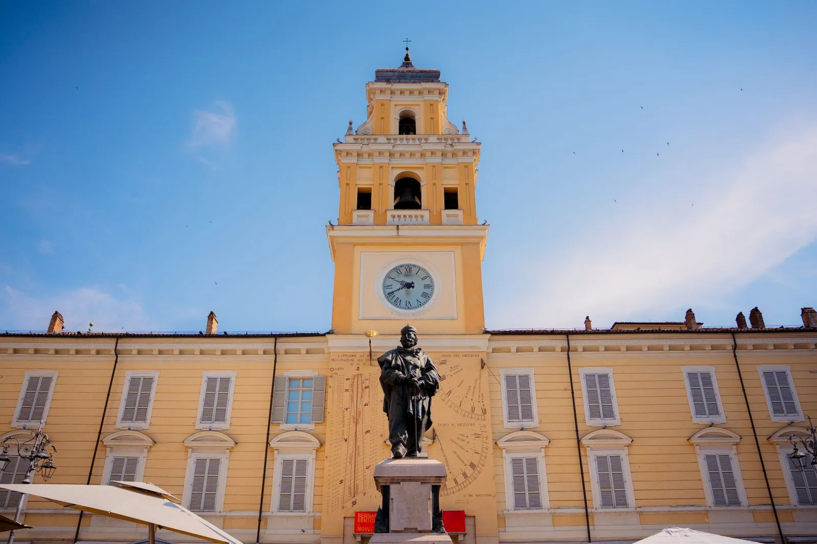 Tour de l’horloge, cadran solaire et statue à Parme.