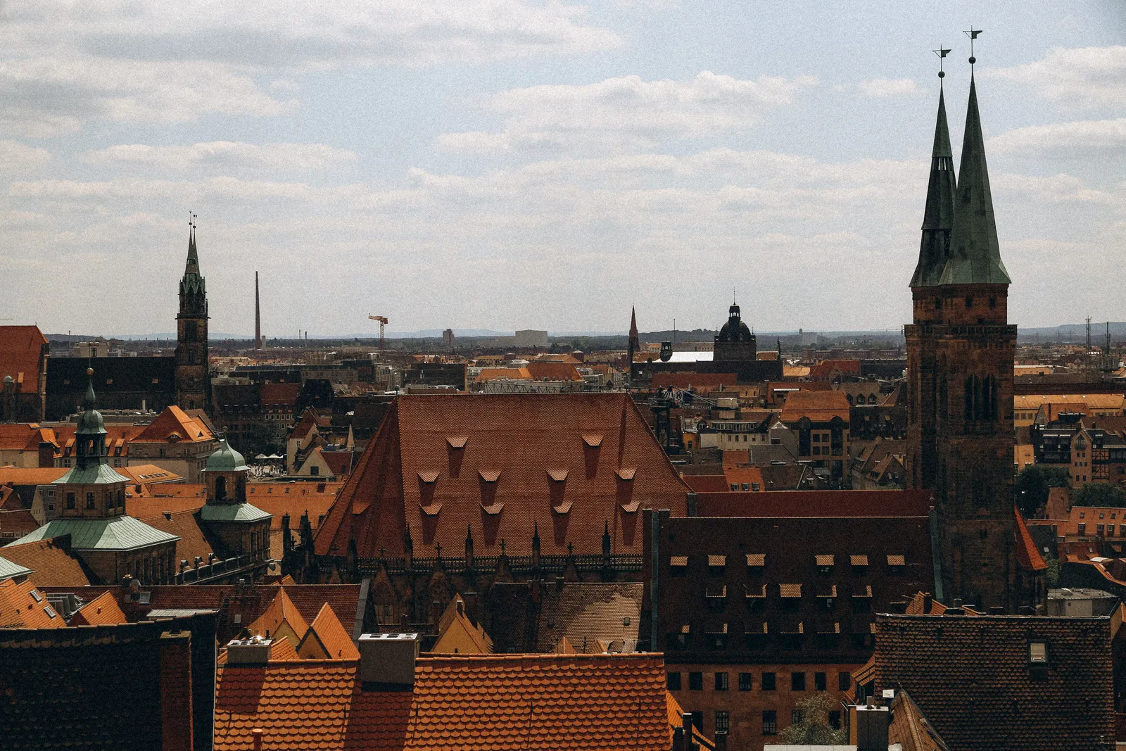 Hustak med röda tegelpannor i Nürnbergs gamla stan, med Sebalduskyrkans två gröna spiror till höger