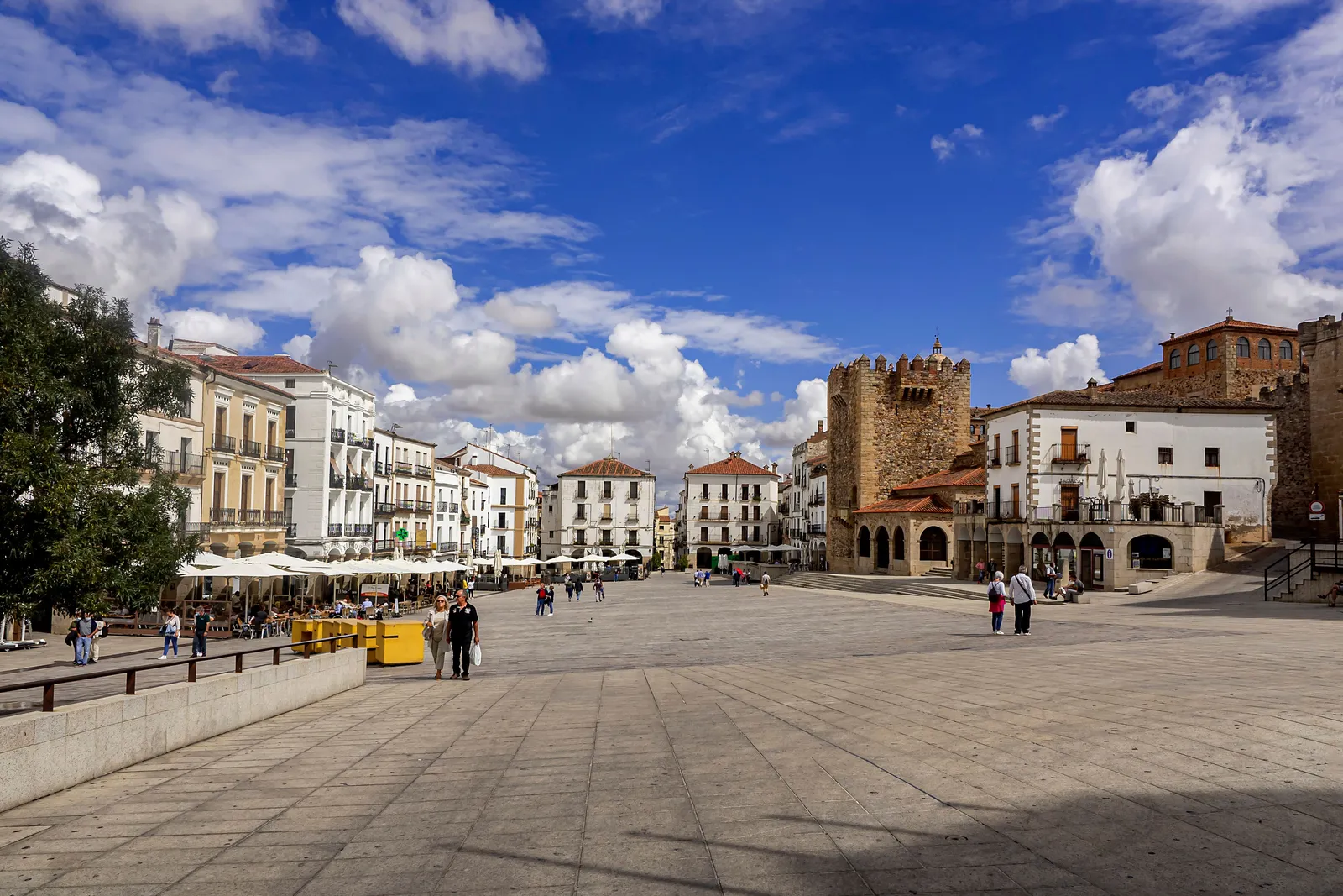 Plaza Mayor a Cáceres con la Torre de Bujaco merlata e gli edifici del centro storico sotto un cielo azzurro