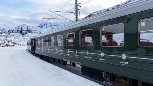 Green Flam Railway train in a snowy mountain landscape